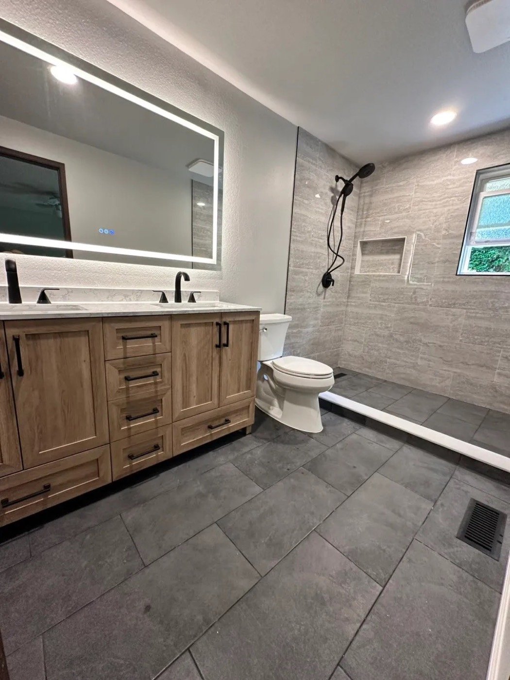 Bathroom with double vanity and tile shower