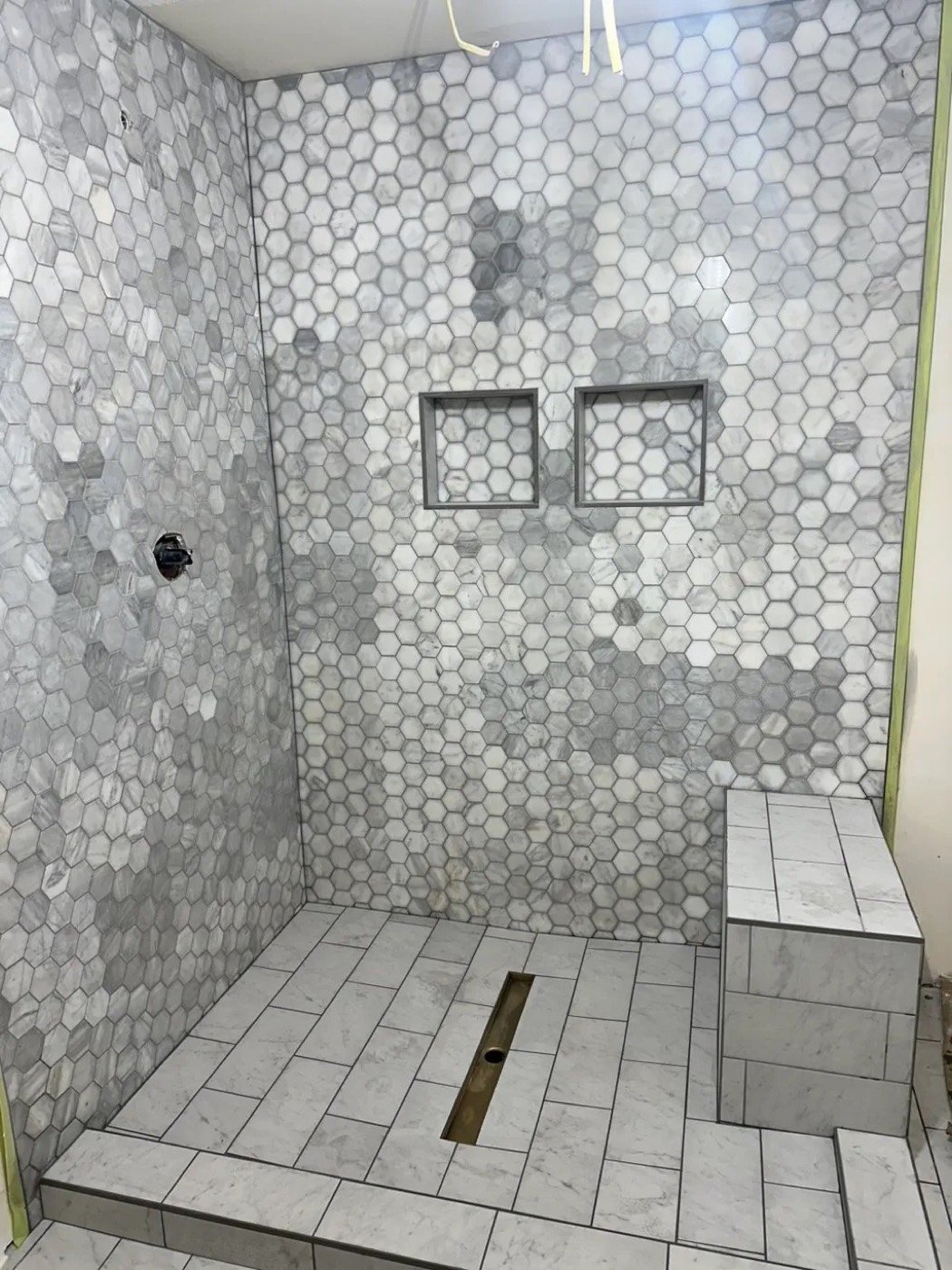 Hexagon mosaic tile shower with niches