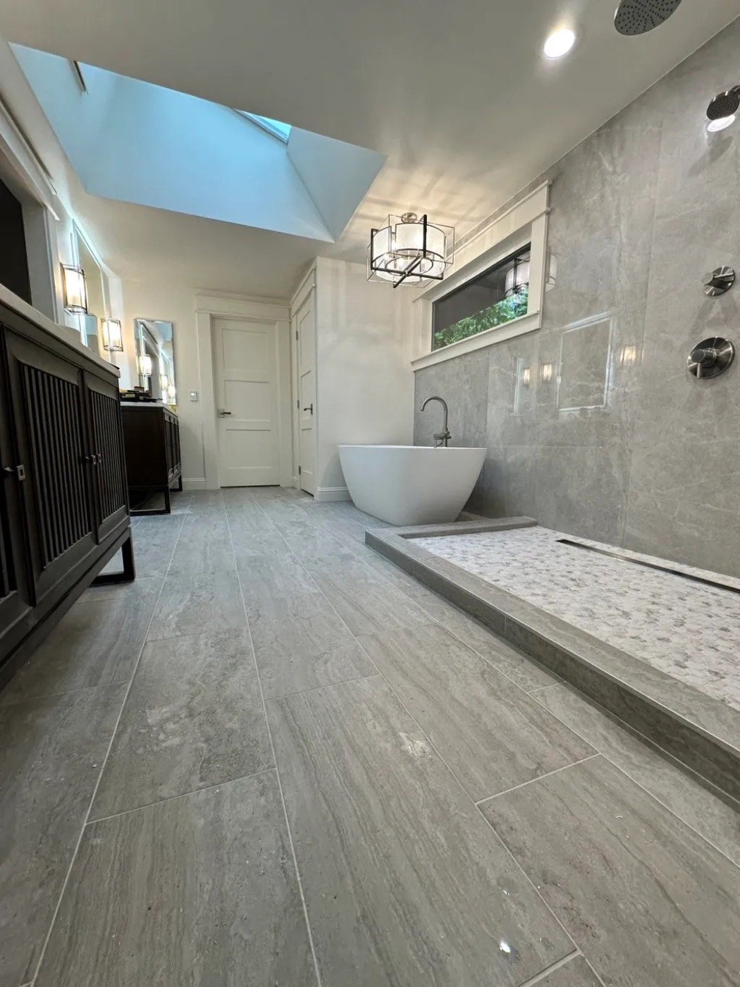 Finished bathroom with large-format tile floor, freestanding tub and walk-in shower in Redmond, WA
